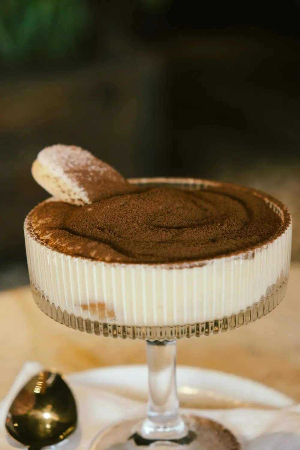 Tiramisù en coupe, poudré de cacao, un biscuit planté sur le dessus